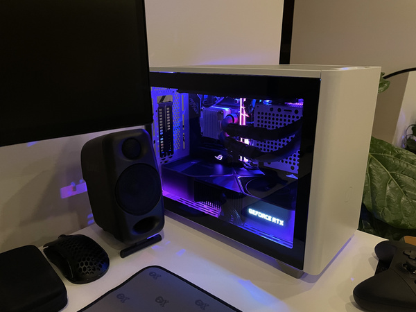 Cooler Master NR200P next to iLoud monitor with purple lighting