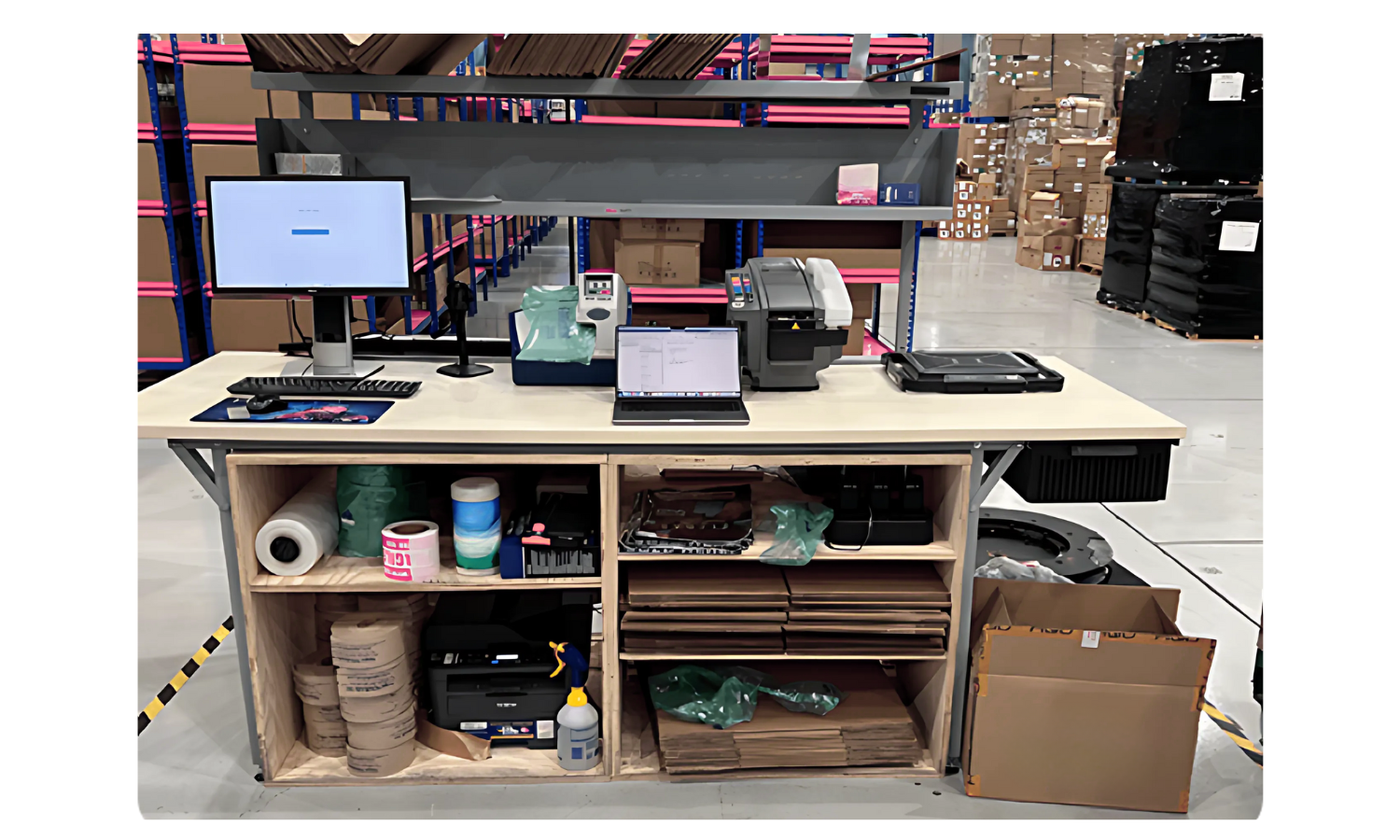 Pick and Pack Station. Warehouse station set up for packing and shipping orders to customers. Many boxes in the background with standup working space in foreground.