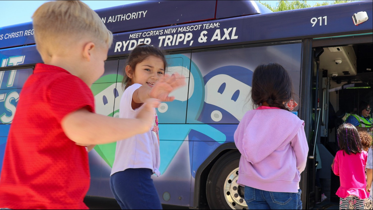 Young children boarding a bus. 