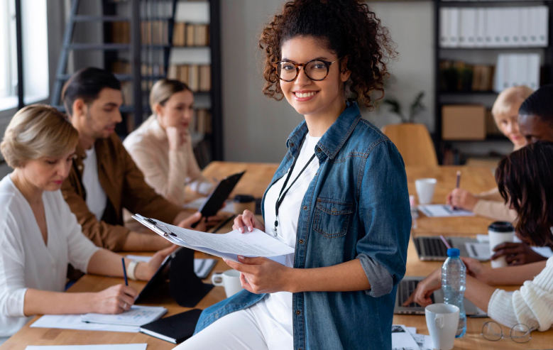 Confident young professional woman leading a team meeting, symbolizing leadership and diversity in the workplace