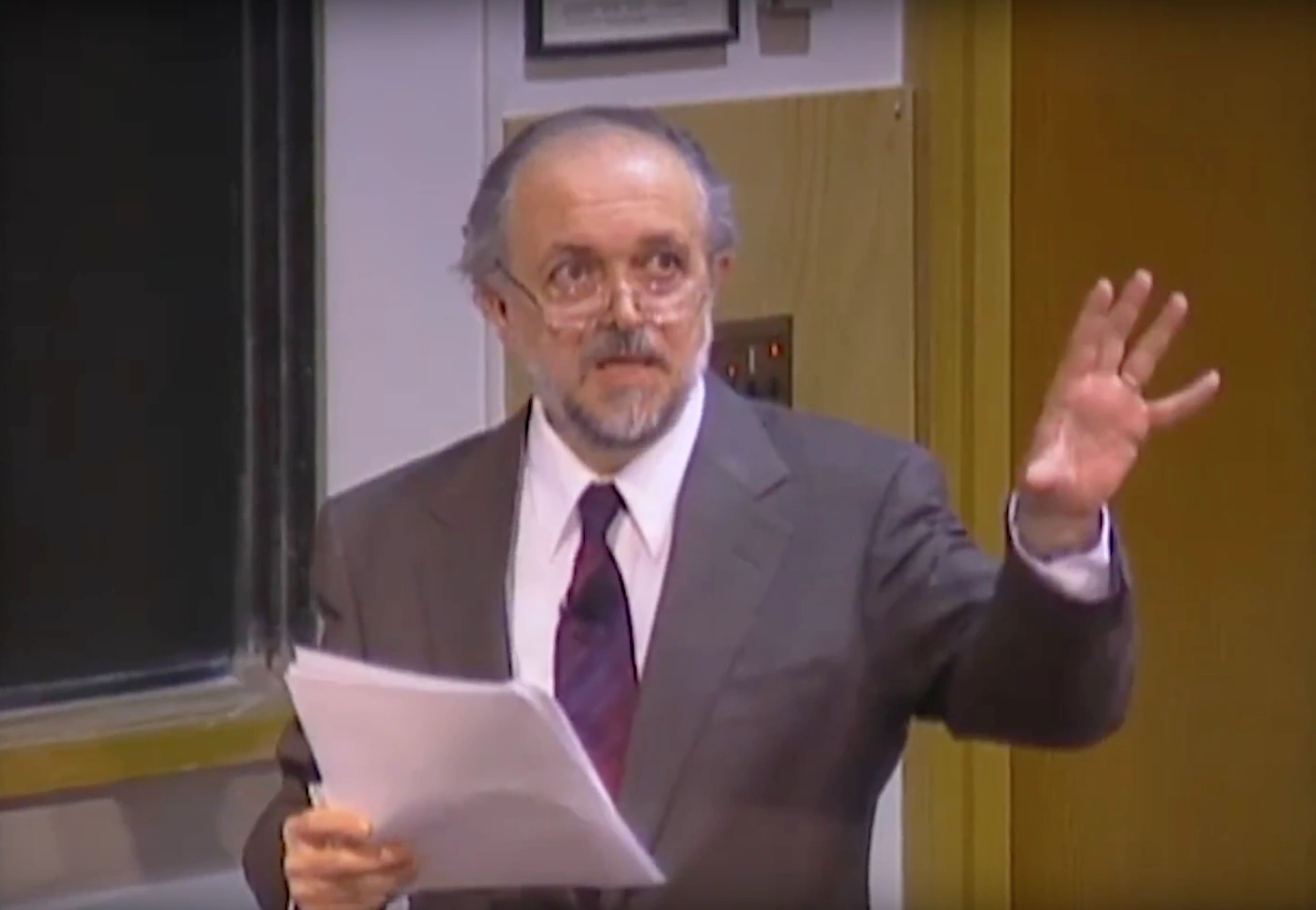 Mario Molina lecturing in a classroom, standing in front of a chalkboard.