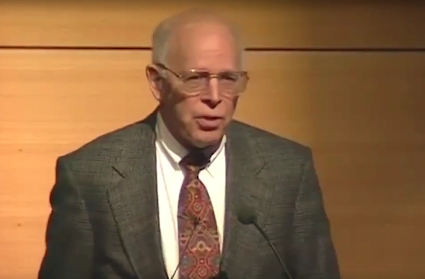 John Gibbons speaking in front of microphone