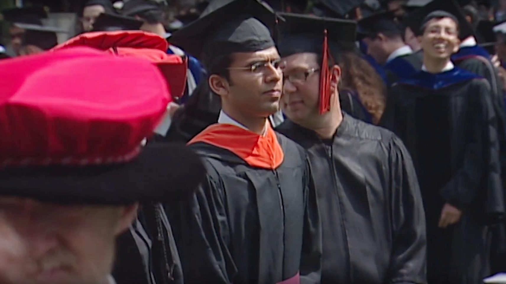 Irwin M. Jacobs, wearing commencement attire, stands in crowd of MIT graduates