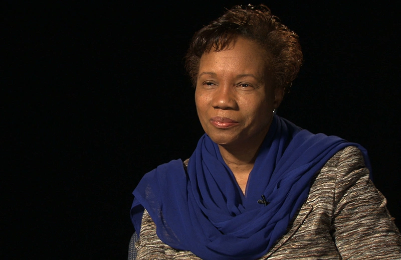 Denise Simmons seated in front of a black background for an on camera interview.