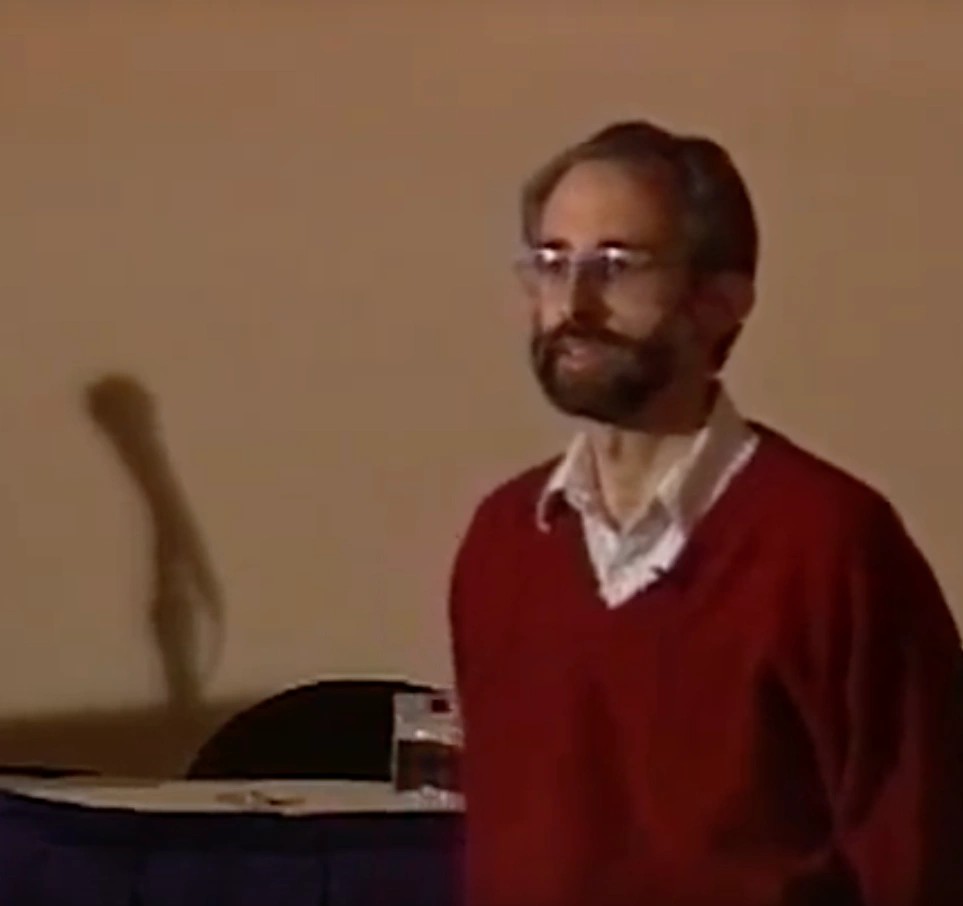 Anthony T. Paterra, wearing a red sweater, in classroom with white walls