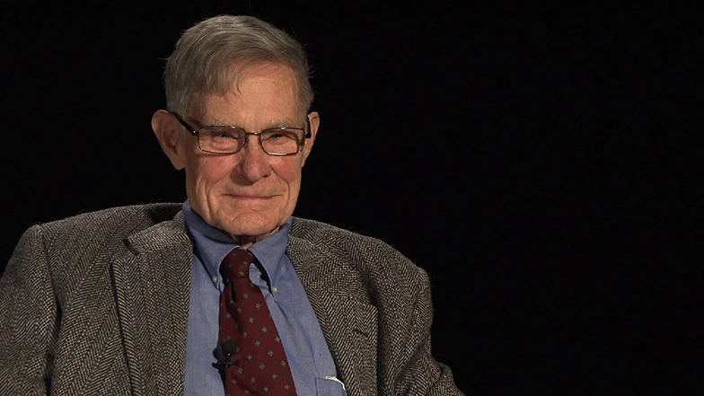 John King seated in front of a black background for an on camera interview.