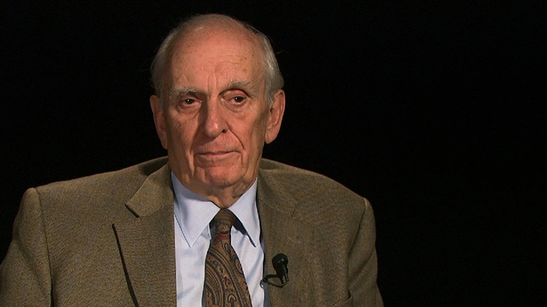 William Pounds seated in front of a black background for an on camera interview.