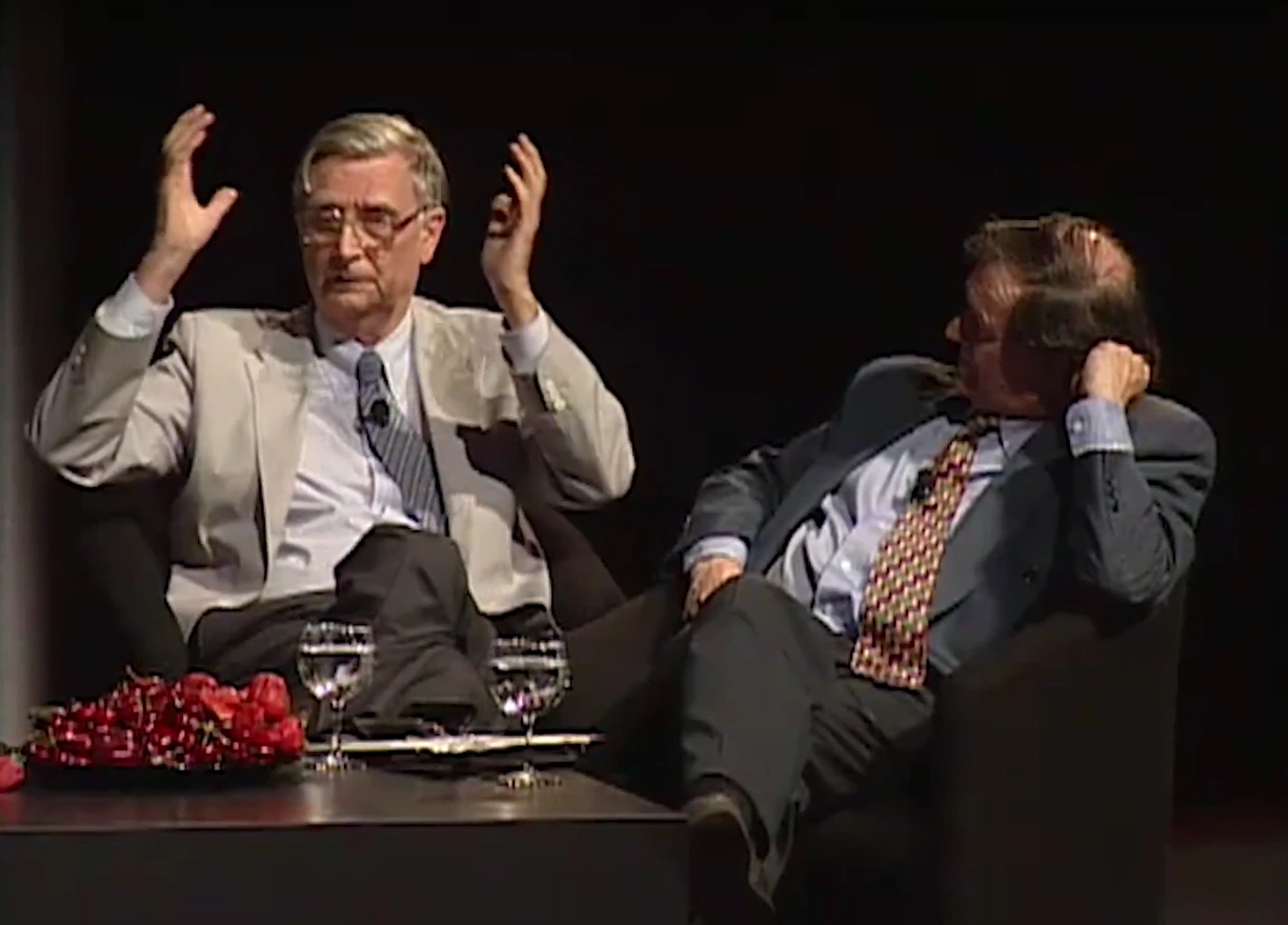 Edward O. WIlson and Sir  Roger Penrose are on stage, seated on chairs around a coffee table, having a lively panelist discussion.