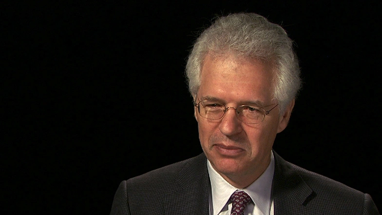 Richard K. Lester seated in front of a black background for an on camera interview.