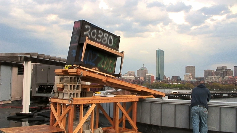 A piano is ready to be launched off of the roof of Baker House