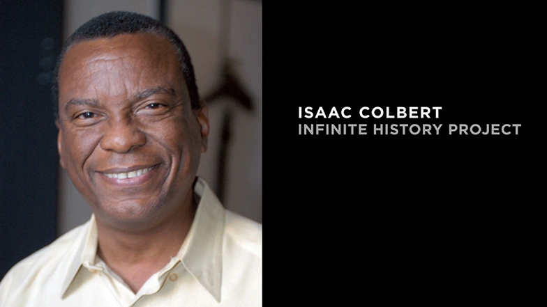 Isaac Colbert smiling in button up shirt.