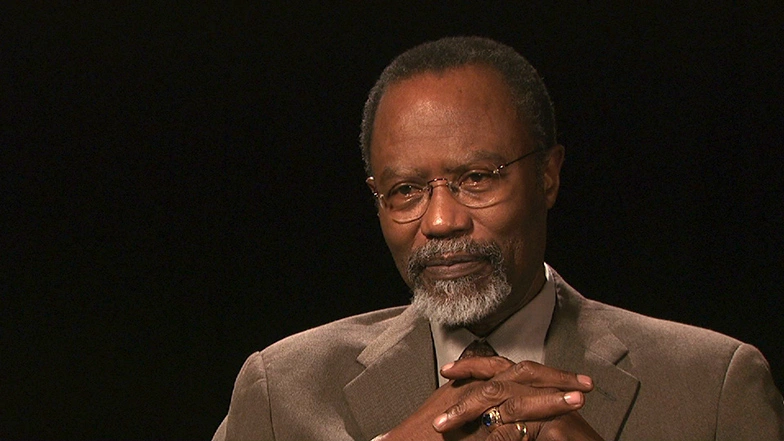 Phillip L. Clay seated in front of a black background for an on camera interview.