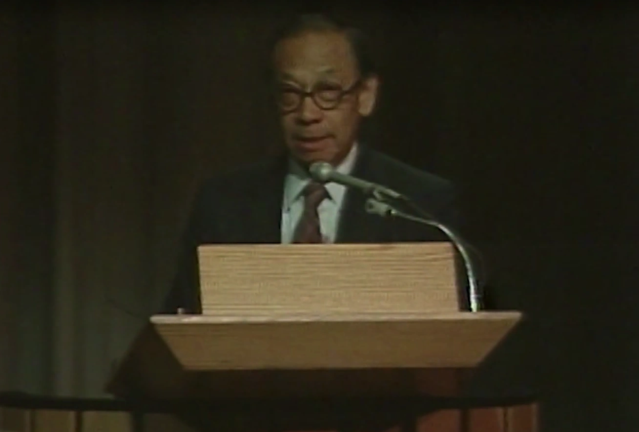I.M. Pei speaking at a podium on stage, in front of a dark background