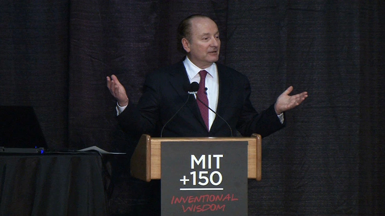 Robert Merton speaking at a podium on stage, in front of a dark background