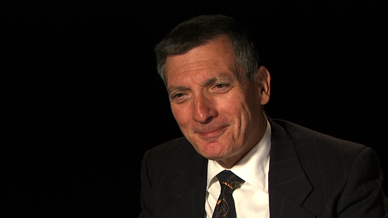 Don Sadoway seated in front of a black background for an on camera interview.