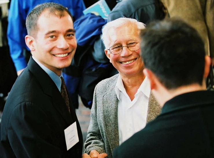 Three men have a conversation outdoors at MIT's Excellence Awards 