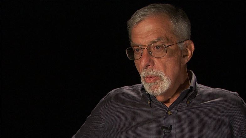 Bob Silbey seated in front of a black background for an on camera interview.