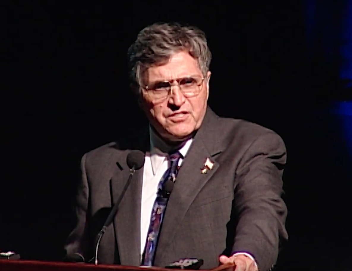 Harrison 'Jack' Schmitt giving a speech at a podium on stage