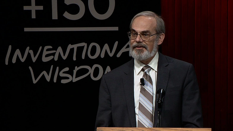 Eric Grimson speaking at a podium onstage at MIT150 Symposium