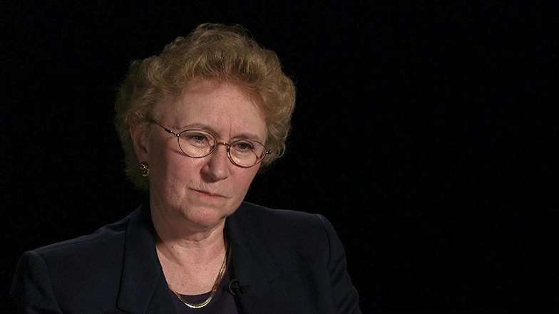 Candace Royer seated in front of a black background for an on camera interview.