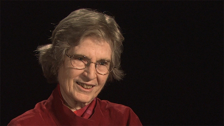 Lotte Bailyn seated in front of a black background for an on camera interview