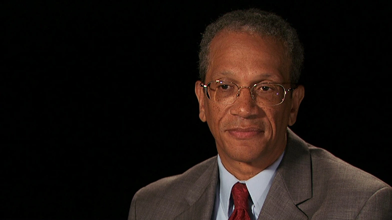Daniel E. Hastings seated in front of a black background for an on camera interview.