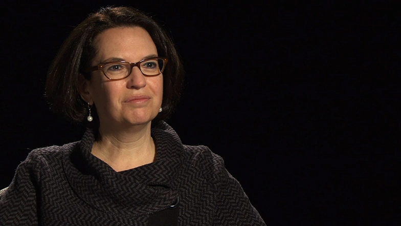 Deborah Ancona seated in front of a black background for an on camera interview.