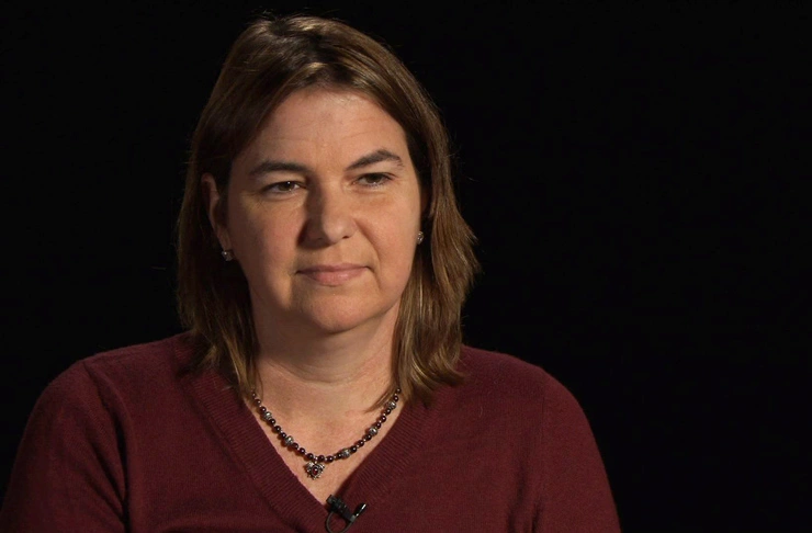 Angela Belcher seated in front of a black background for an on camera interview.