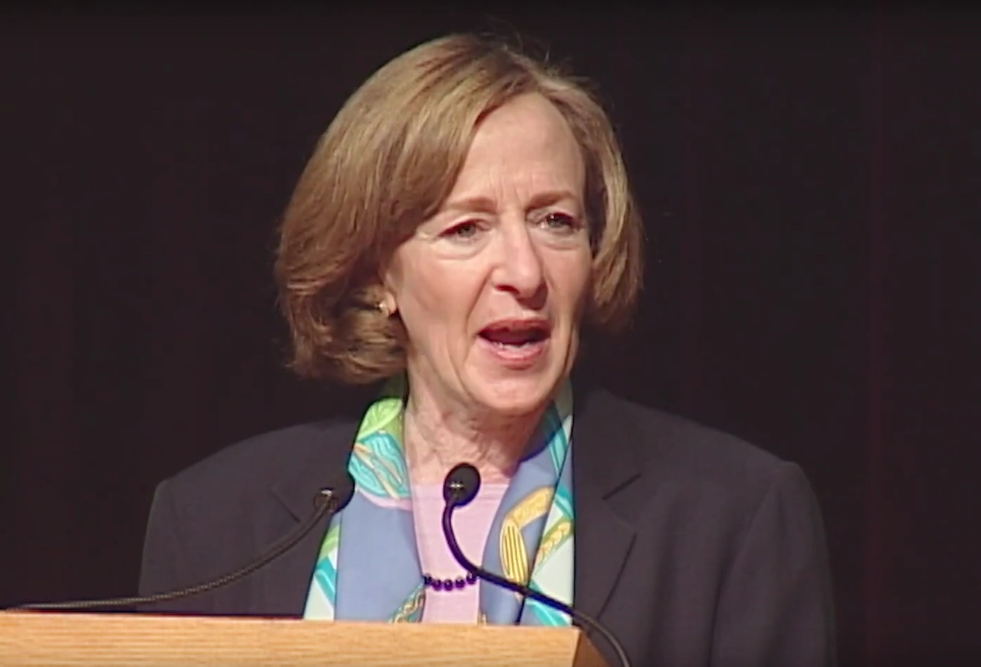 Susan Hockfield speaks at podium onstage in front of dark background