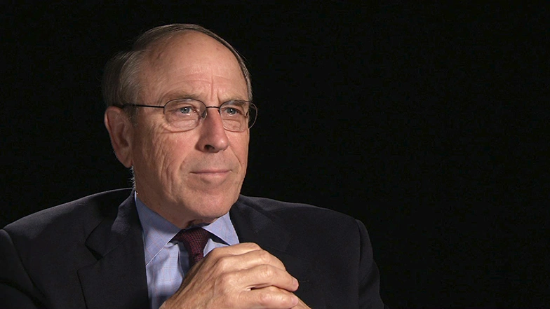 Glenn Strehleseated in front of a black background for an on camera interview.