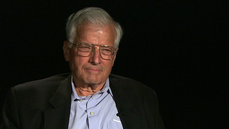 Kenneth A. Smith seated in front of a black background for an on camera interview.