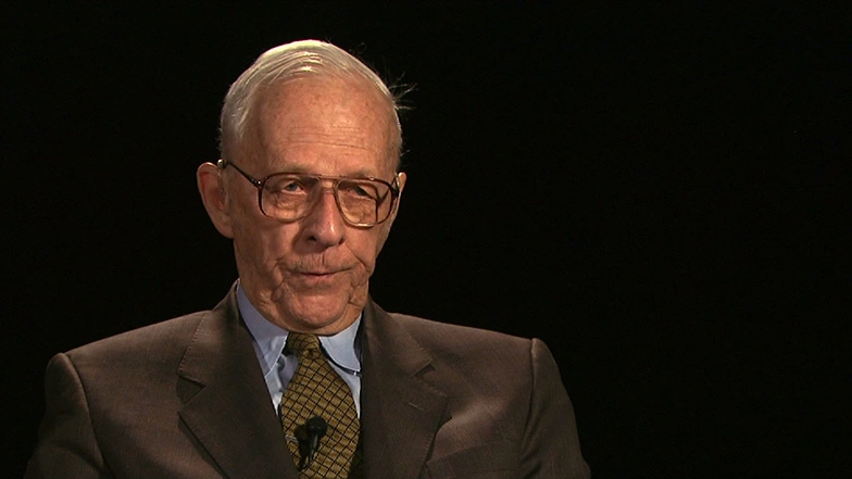 Jay Forrester seated in front of a black background for an on camera interview.