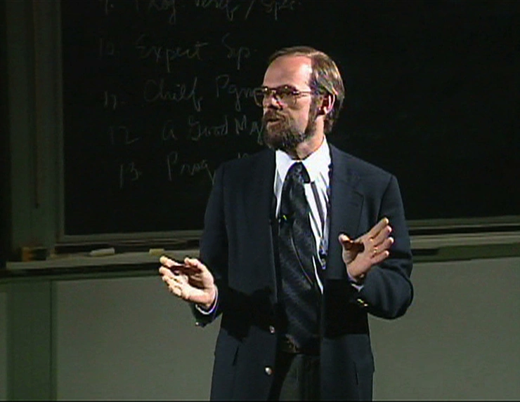 Eric Grimson lecturing in a classroom, a chalkboard in the background.