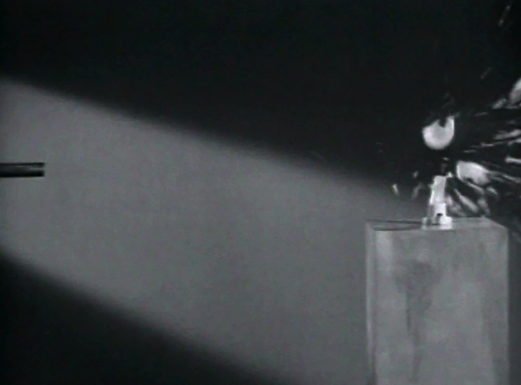 A bullet passing through a lightbulb, shattering it. Black and white photo captured by the stroboscope.