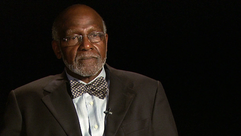 Wesley Harrisseated in front of a black background for an on camera interview.