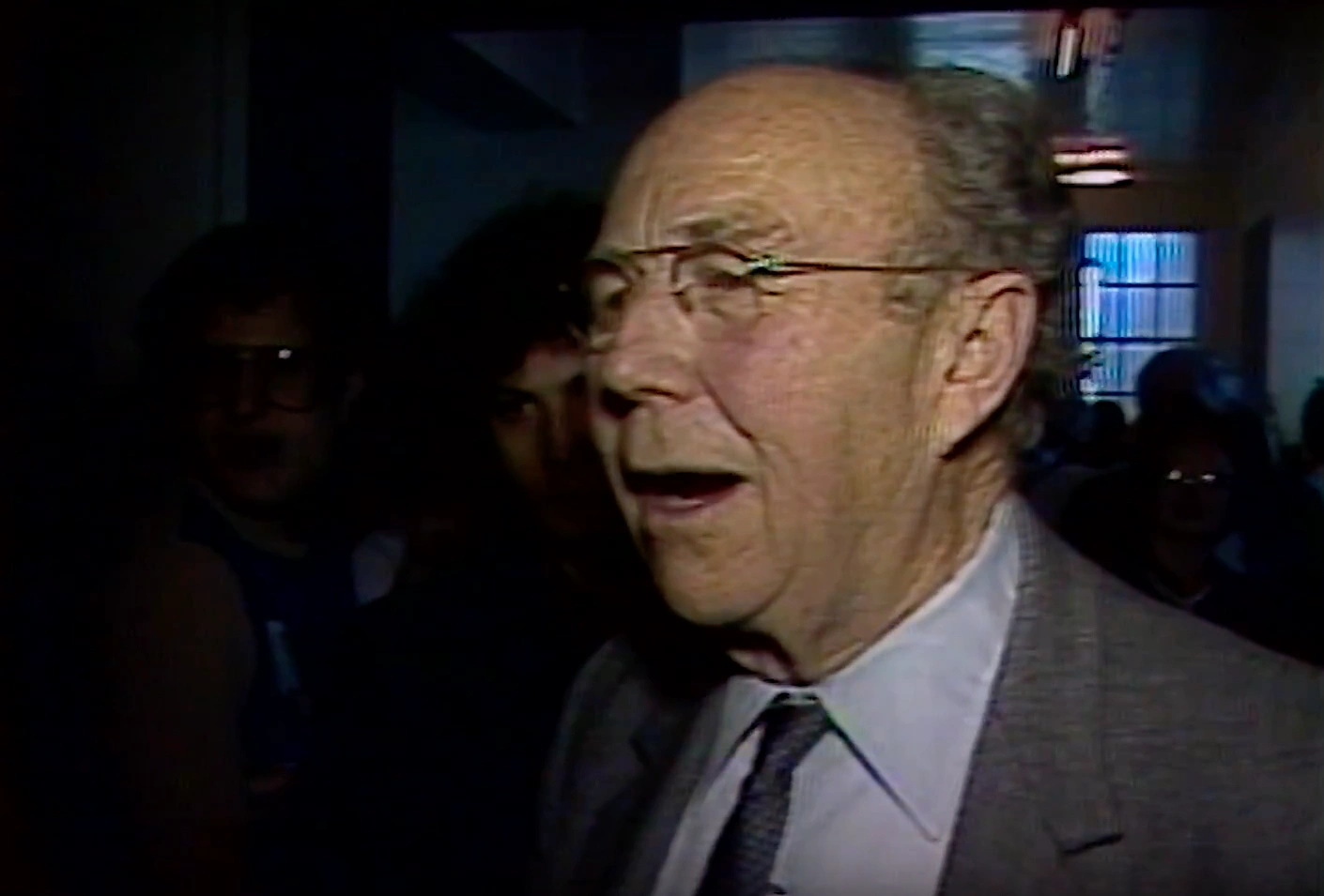 Doc Edgerton laughing in dark, crowded event space for his birthday.