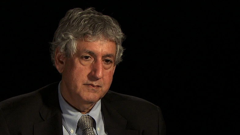 Philip S. Khoury seated in front of a black background for an on camera interview.