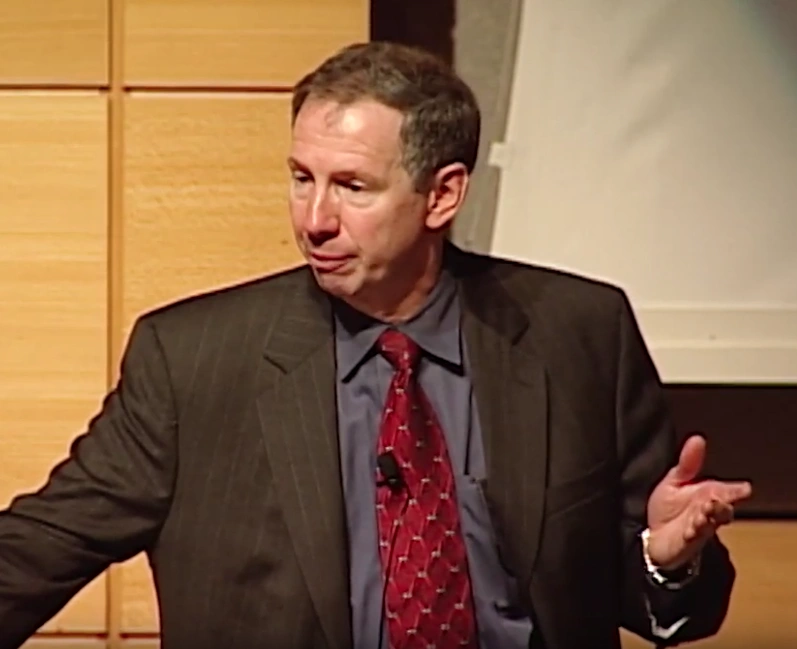 Michael D. Griffin giving a presentation in front of a projector screen