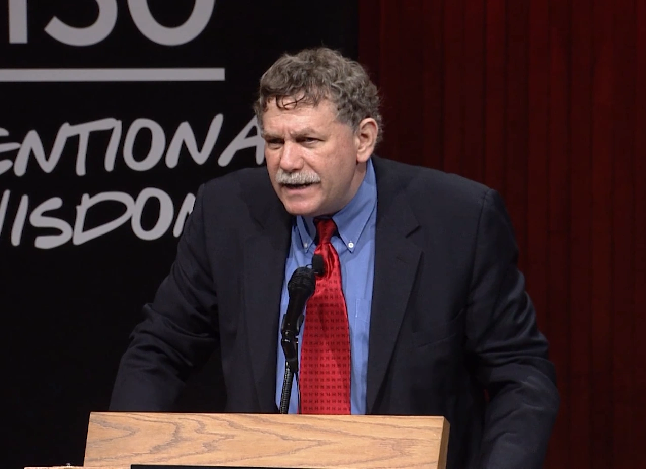 Eric Lander speaking at a podium onstage at MIT150 Symposium