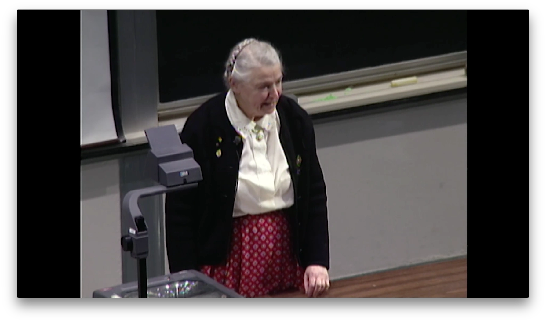 Mildred Dresselhaus standing beside an overhead projector in front of a chalkboard