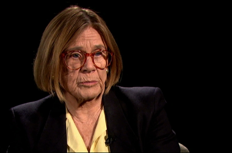 Sheila Widnall seated in front of a black background for an on camera interview.