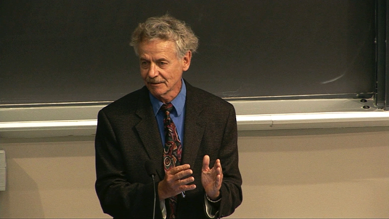Professor Rudolf Jaenisch lecturing in a classroom, a chalkboard in the background