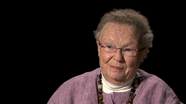 Priscilla Gray seated in front of a black background for an on camera interview.