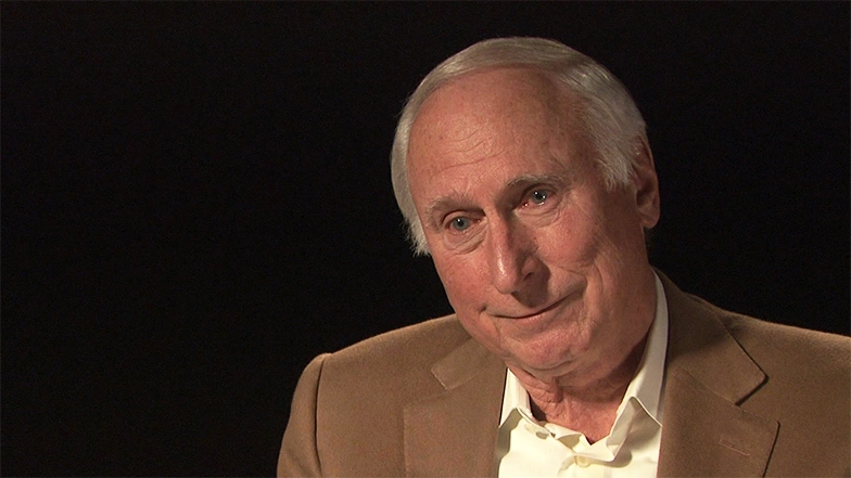 Raymond S. Stata seated in front of a black background for an on camera interview.