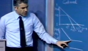 Professor standing and pointing at chalk board