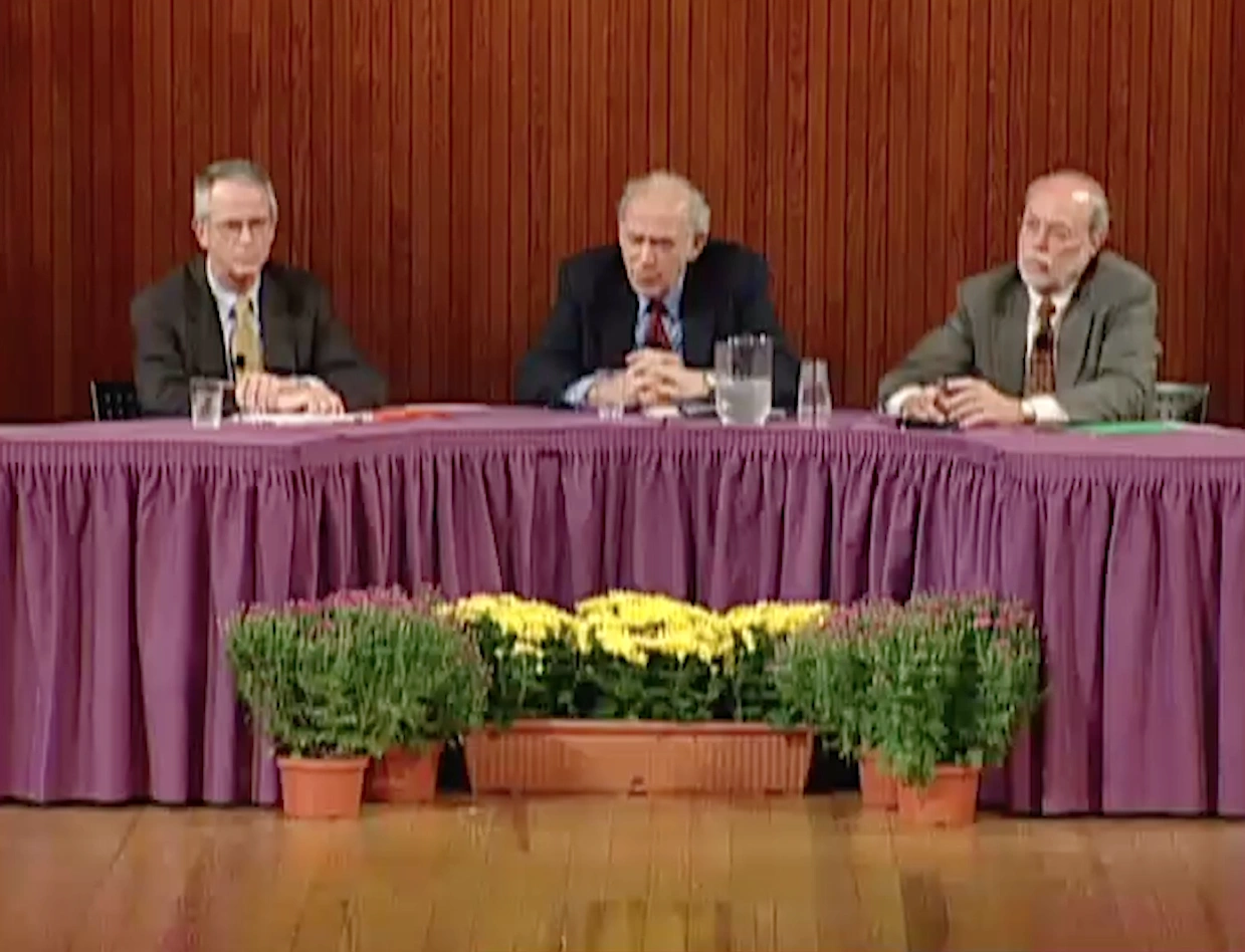 Jerome Friedman, Philip Sharp, and Charles Vest sit onstage at panelist table. Red curtain in the background.