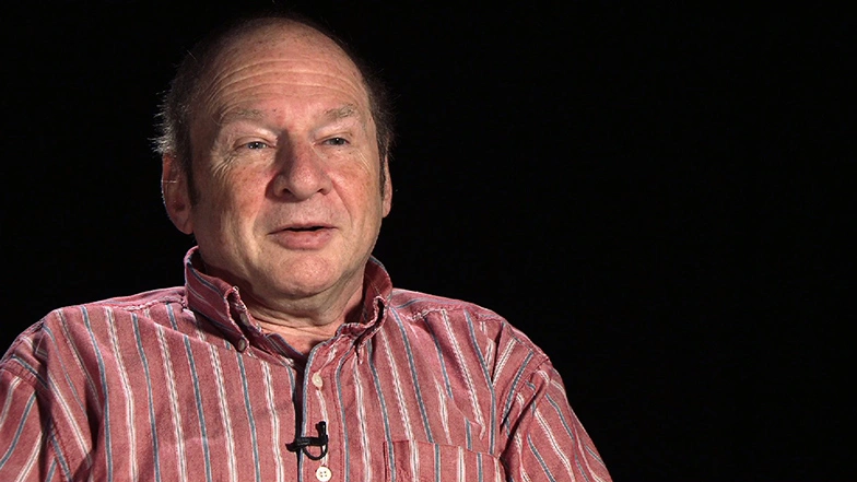 Harold Abelson seated in front of a black background for an on camera interview.