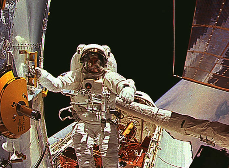 Jeffrey Hoffman floating backwards out of his spacecraft into outerspace