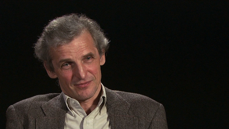 Wolfgang Ketterle seated in front of a black background for an on camera interview.